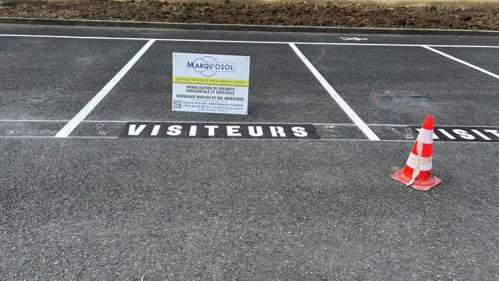 Réalisation du marquage au sol en peinture routière. Les supports du lettrages sont en enduit. Pour plus d'infos: https://www.marqu-osol.fr/